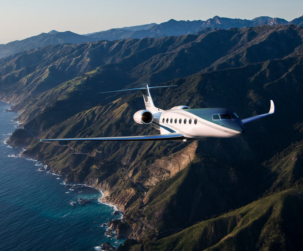 Gulfstream G800 in flight over green mountains and sea 